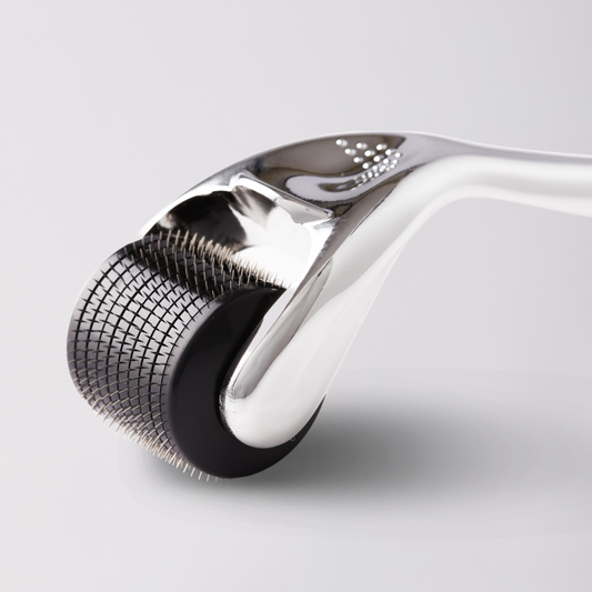 Close-up of a derma roller with metallic head on a light gray background